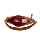 Interior view of a light brown leather handbag with silver accents on a white background