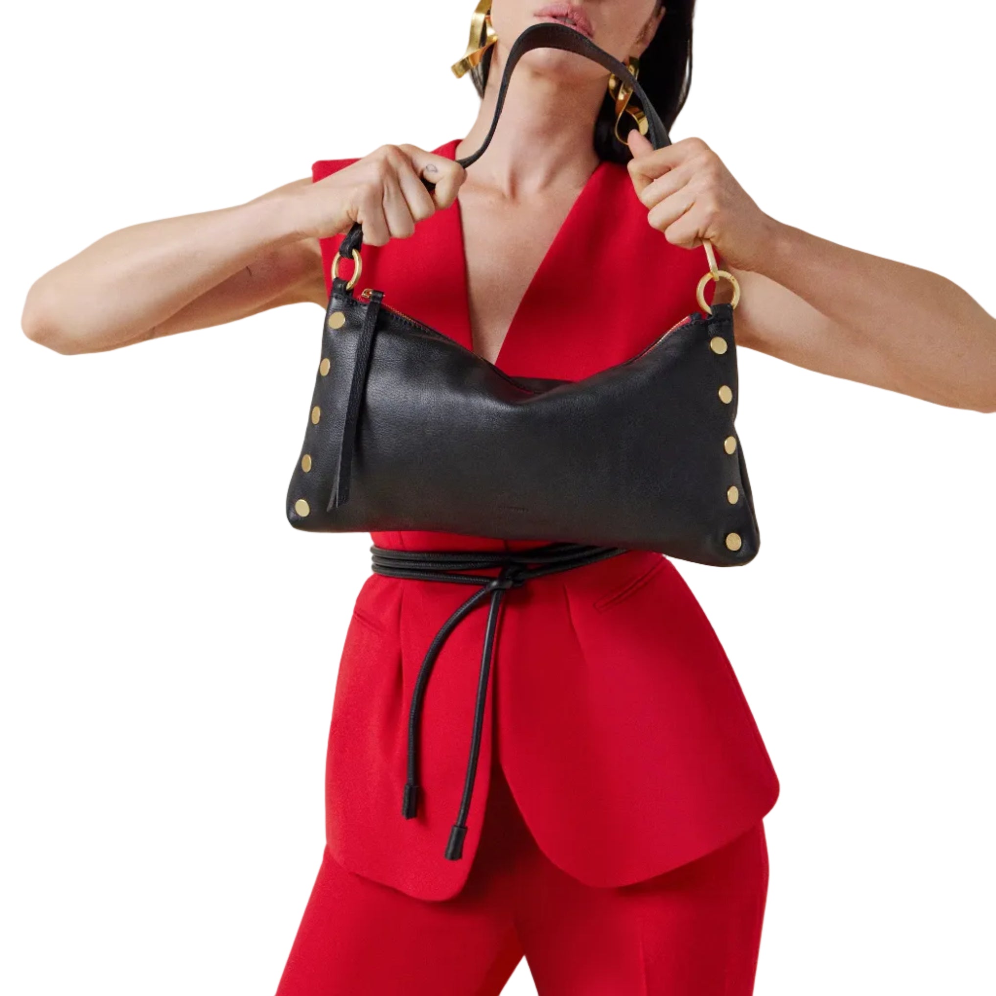 Model in a red outfit with a black leather convertible bag with red and gold accents on a white background