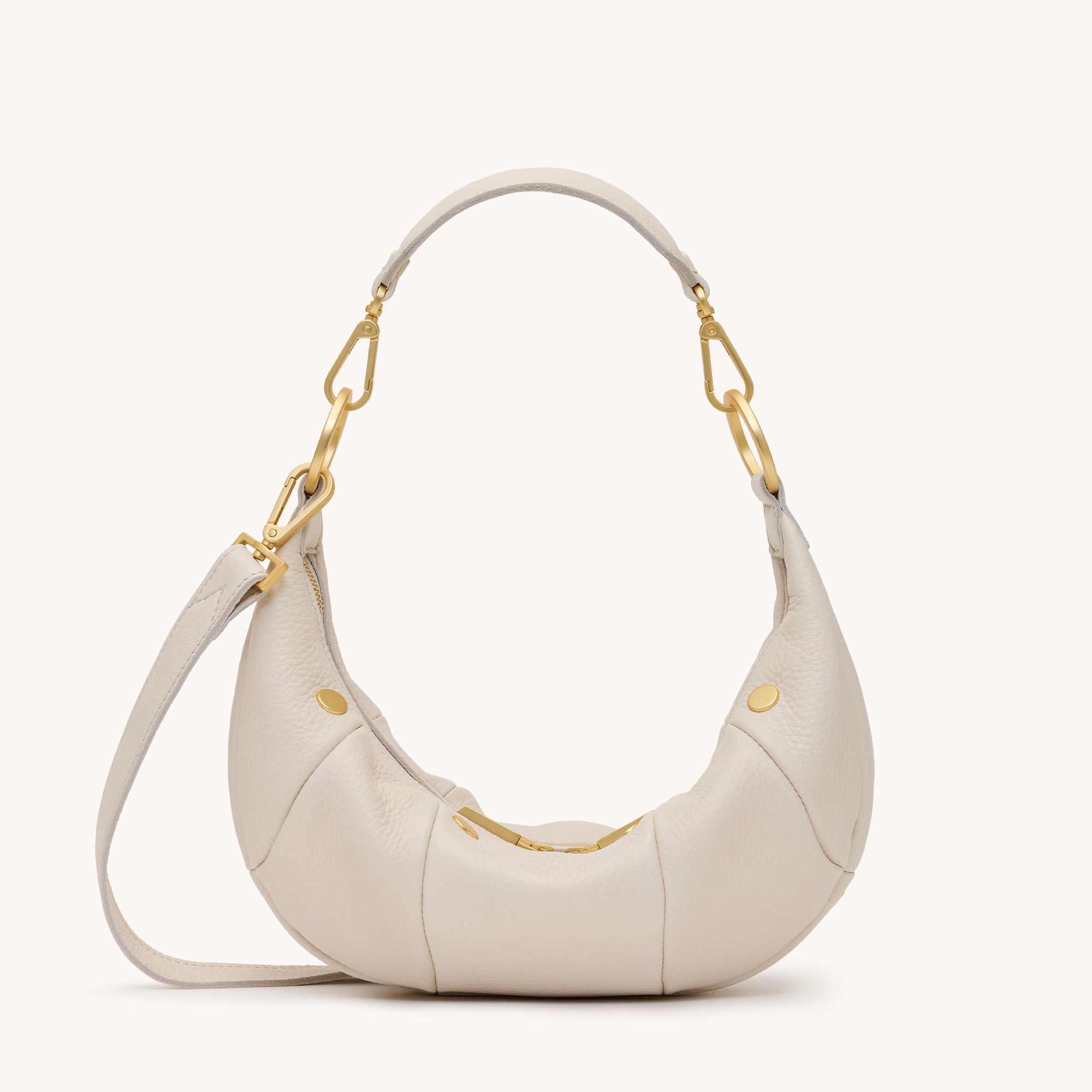 Cream leather handbag with gold accents on a white background