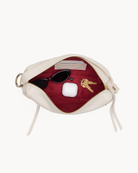 Interior view of a white crossbody bag with gold accents on a white background