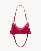 Magenta leather convertible bag with gold accents on a white background
