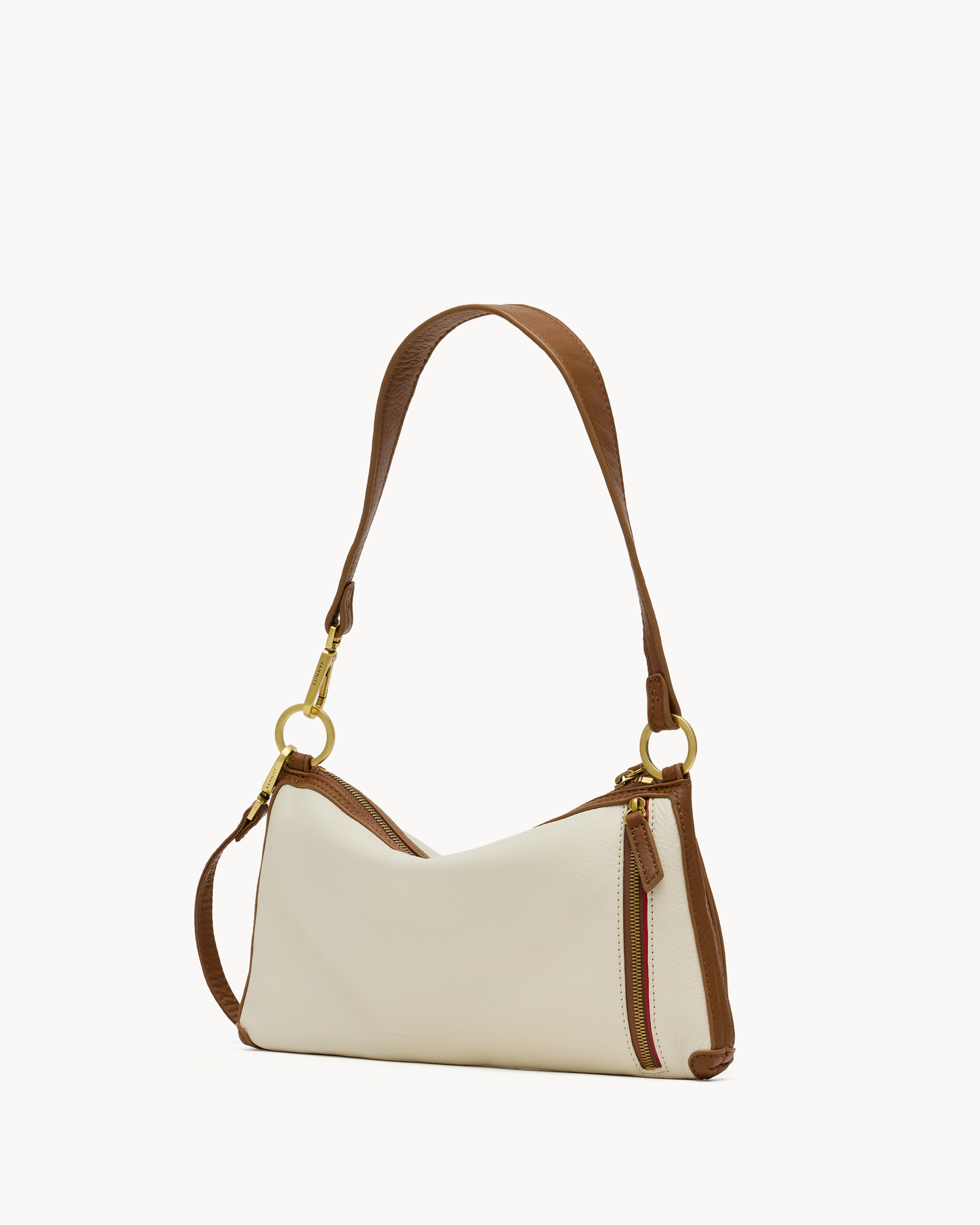 Back view of a cream convertible handbag with brown & gold accents on a white background 