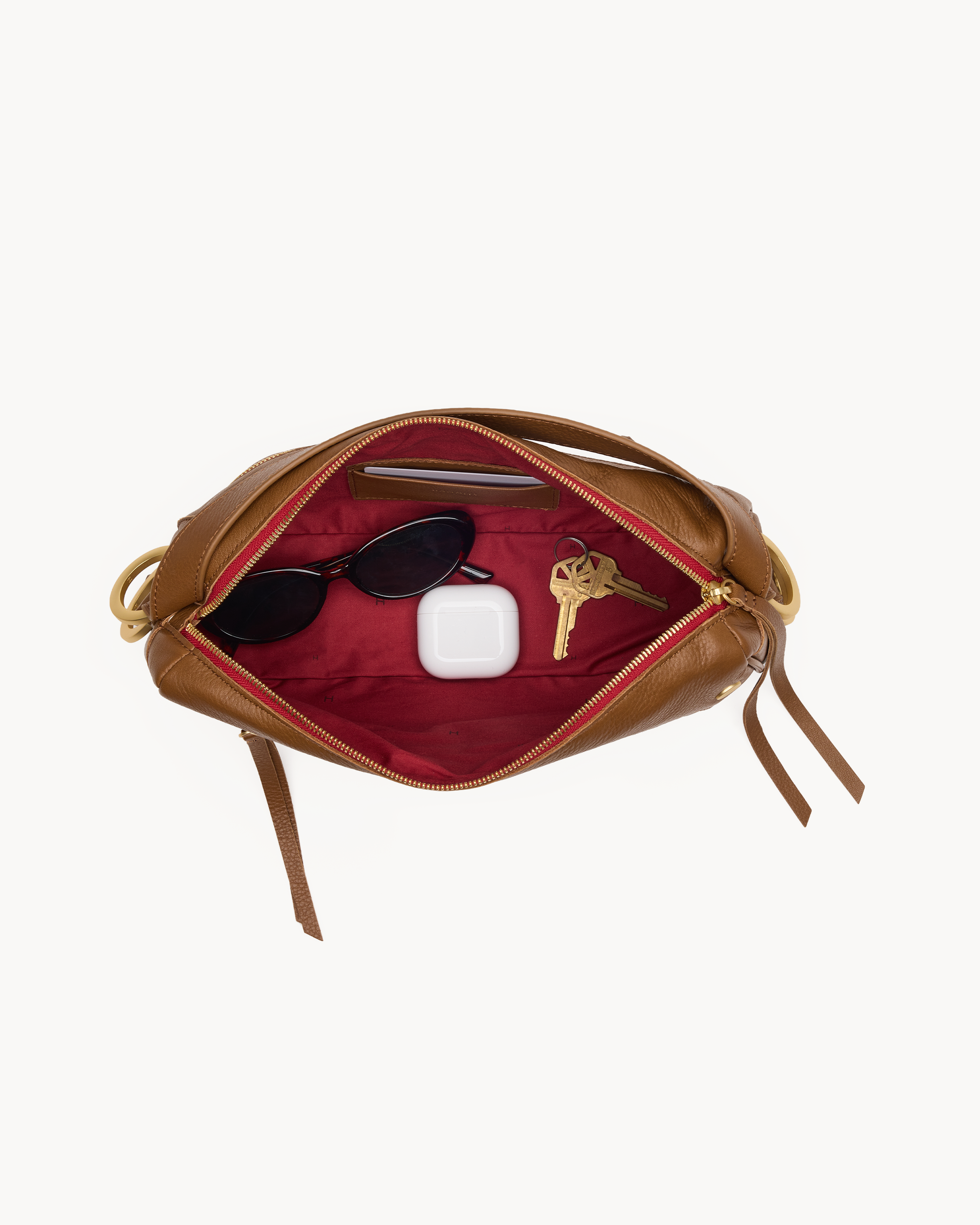 Interior view of a brown cross body bag with gold accents on a white background