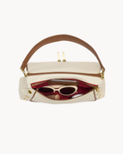 Interior view of a cream purse with brown trim on a white background