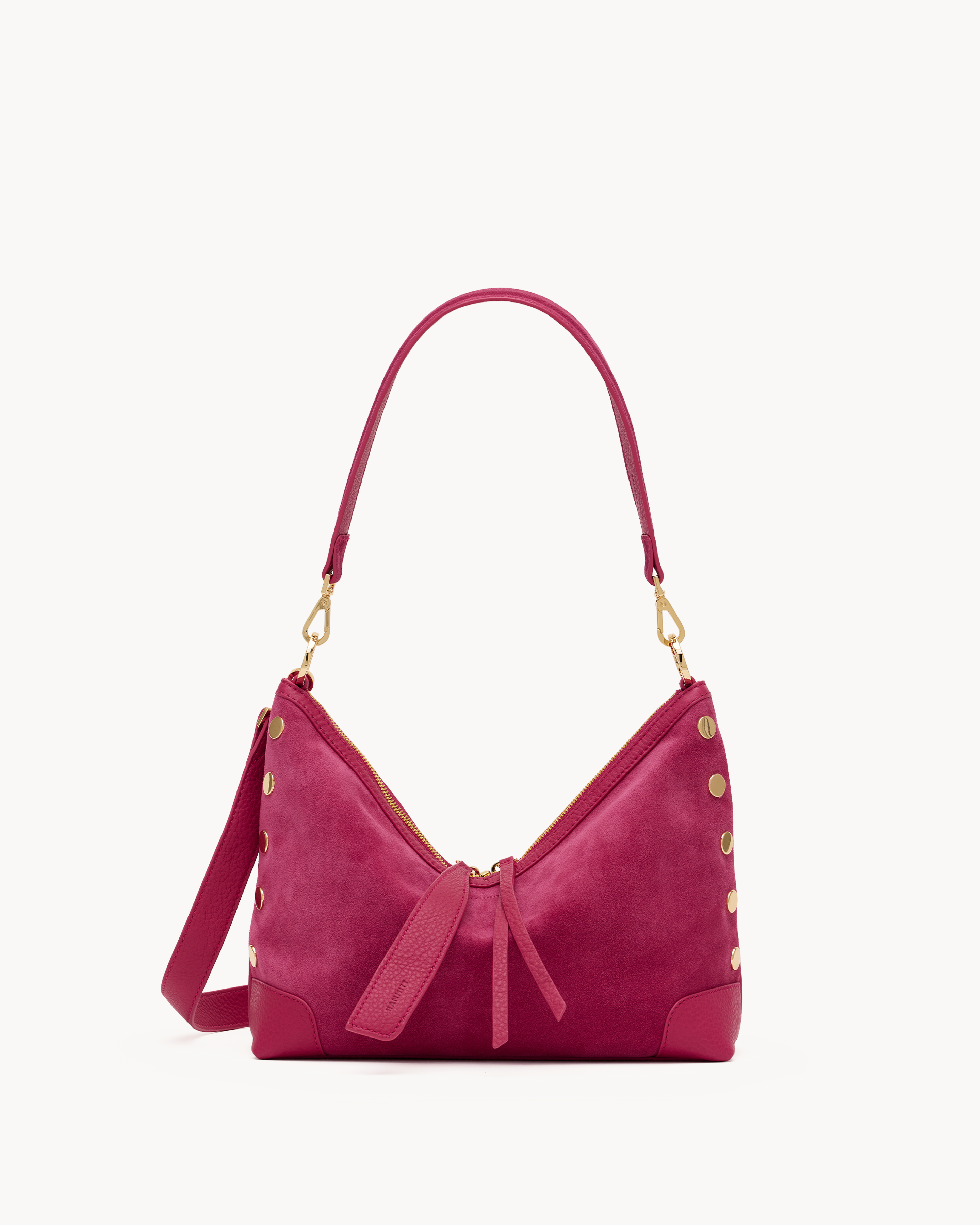 Pink suede handbag with gold accents on a white background