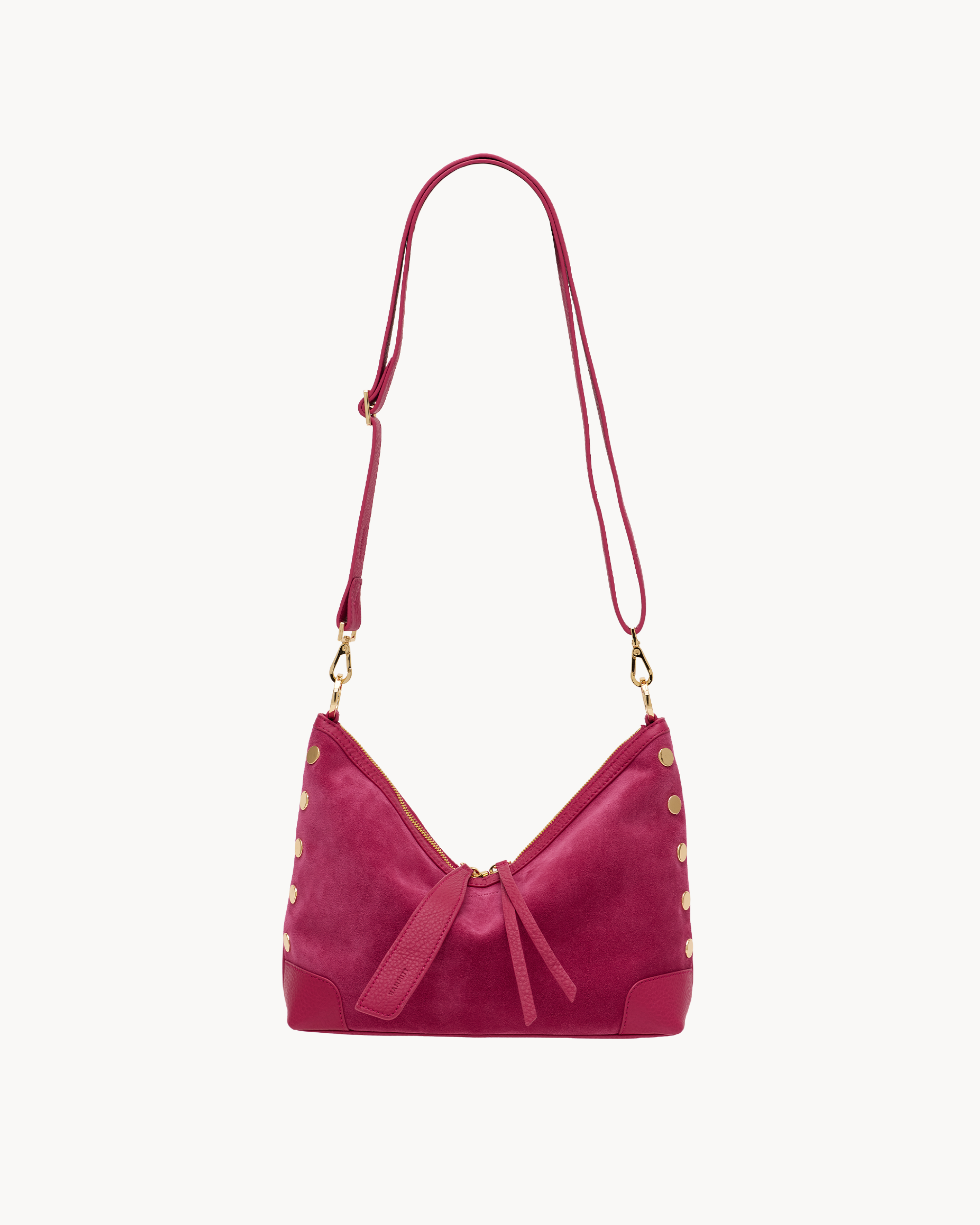 Pink suede cross body bag with gold accents on a white background