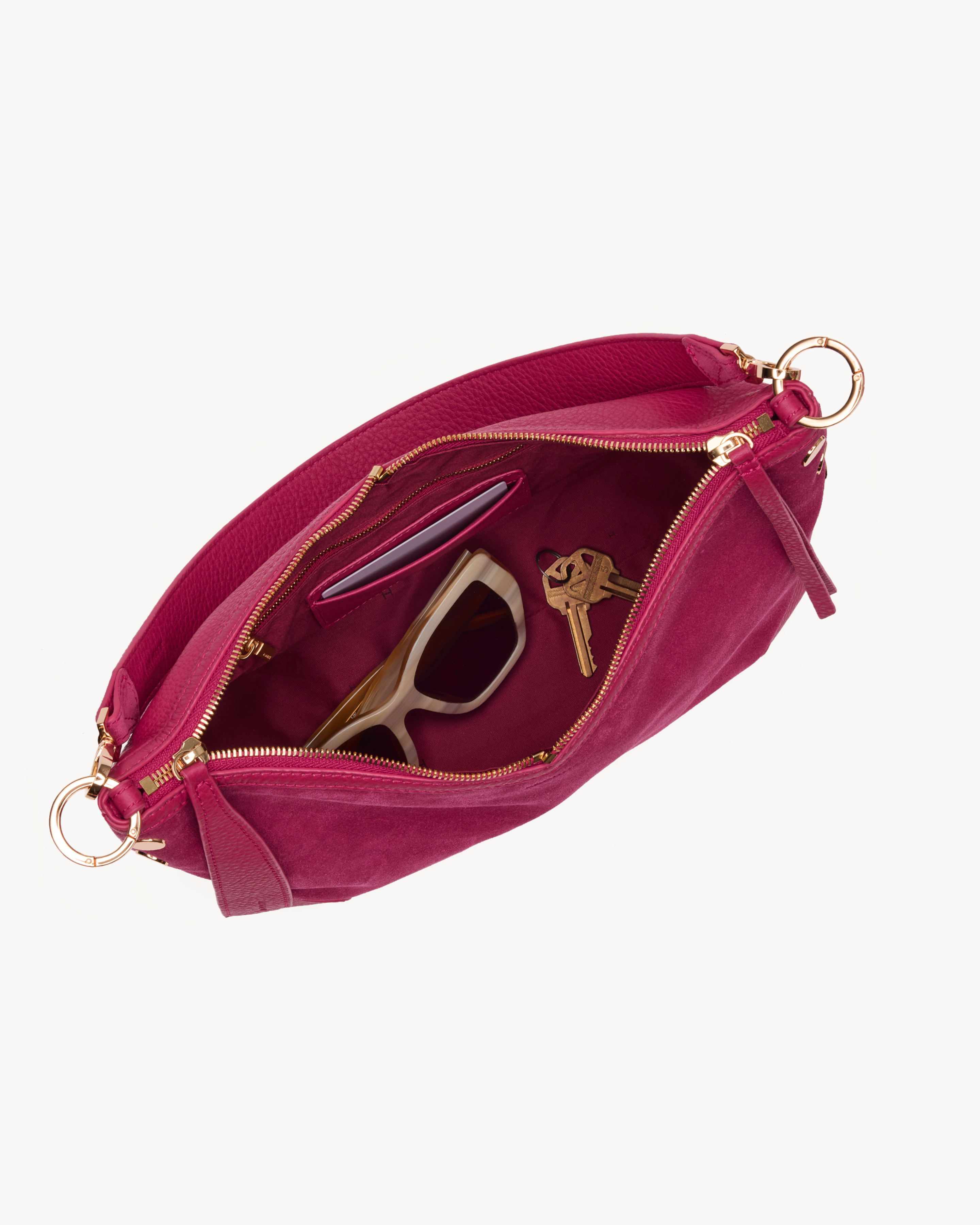 Interior view of a Pink suede handbag with gold accents on a white background