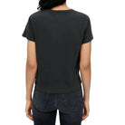 Model in a black t-shirt and black jeans on a white background