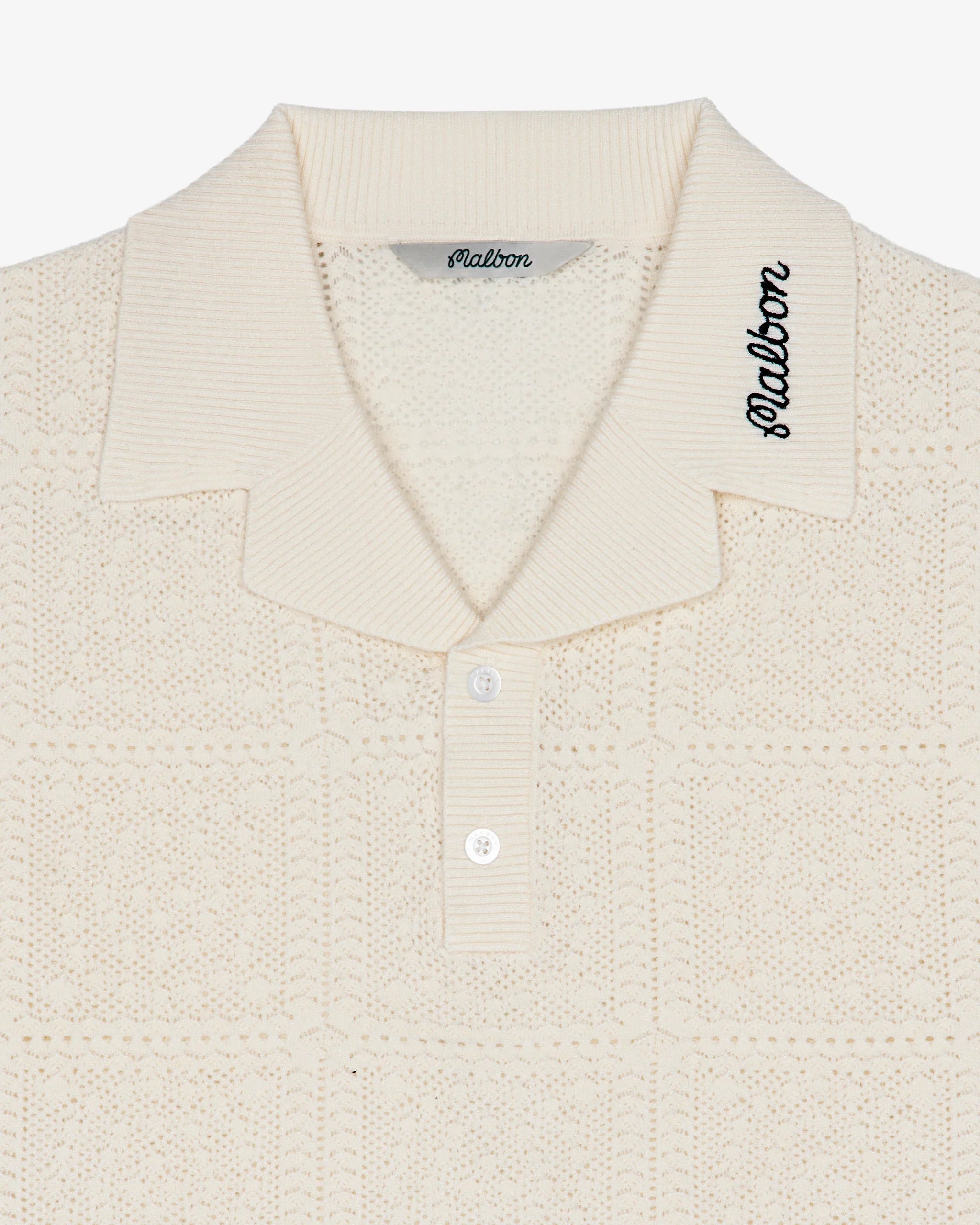 Close-up of a textured beige shirt with 'Malbon' branding on a white background