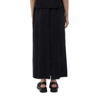 Person wearing a black outfit with a long skirt and top on a white background