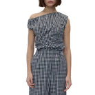 Model in a black and white check asymmetric sleeveless top