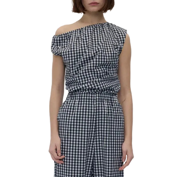 Model in a black and white check asymmetric sleeveless top