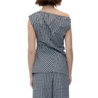 Back view of a model in a black and white check asymmetric sleeveless top