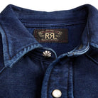 Close-up of a blue denim jacket with Ralph Lauren logo and button details.