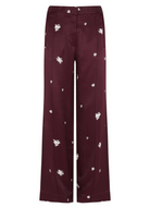 Maroon pants with white floral patterns on a white background