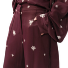Maroon outfit with white floral patterns on a plain background
