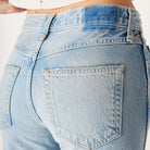 Light blue jeans worn by a person on a plain background
