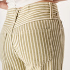 Close-up of a person wearing beige and white striped pants on a plain background