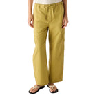Person wearing a white top and mustard yellow pants on a white background