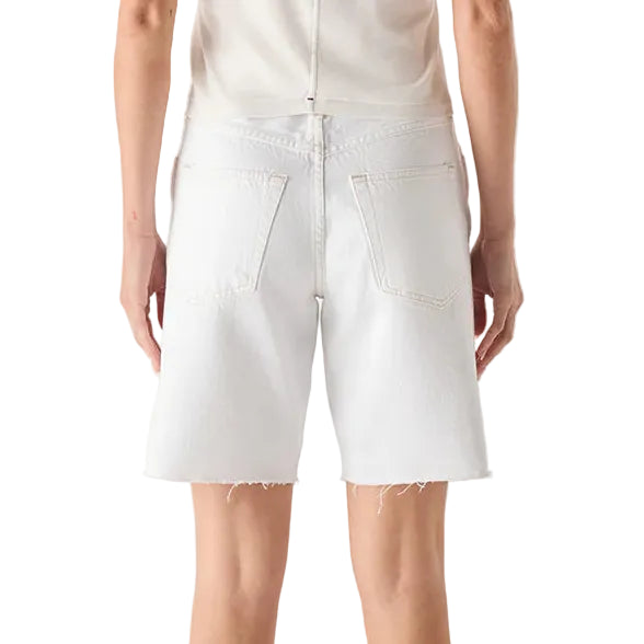 Person wearing a white sleeveless top and white shorts on a plain background