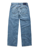 Light blue denim jeans shown from the back, featuring a classic five-pocket design and a dark blue brand patch on the back waistband, photographed against a clean white background.
