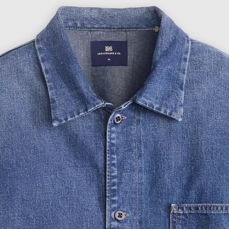 Blue denim shirt with collar and button details on a white background