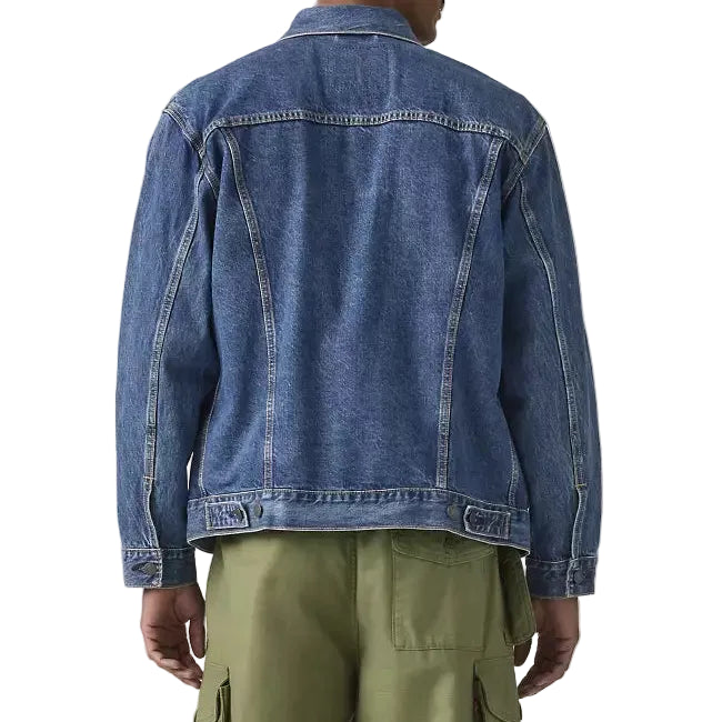Person wearing a blue denim jacket and green cargo pants on a plain background