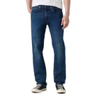 Man wearing a white t-shirt and blue jeans on a plain background