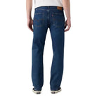 Man wearing blue jeans and a white t-shirt on a plain background