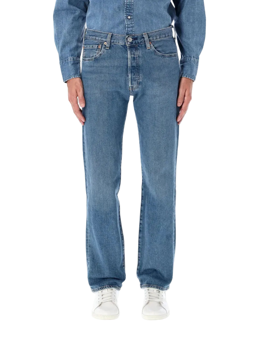 Person wearing blue jeans and a denim jacket on a white background