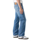 Person wearing a white t-shirt and blue jeans on a plain background