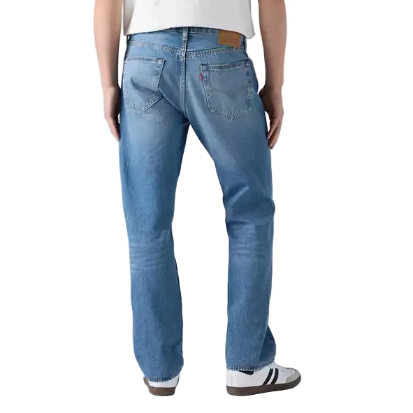 Person wearing a white t-shirt and blue jeans on a plain background