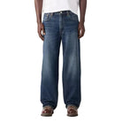 Man wearing a white t-shirt and blue jeans on a white background