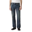 Person wearing a white t-shirt and blue jeans on a plain background