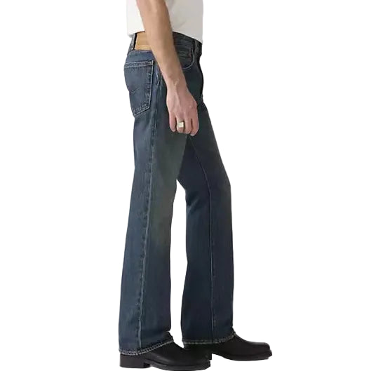 Person wearing a white t-shirt and blue jeans standing against a plain background