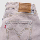 Close-up of Levi's jeans with brand label and pocket detail on a light background