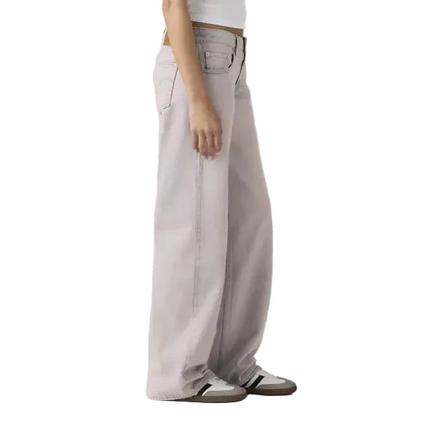 Person wearing a white tank top and light gray pants on a plain background