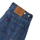 Close-up of blue jeans with Levi's logo and label on a white background