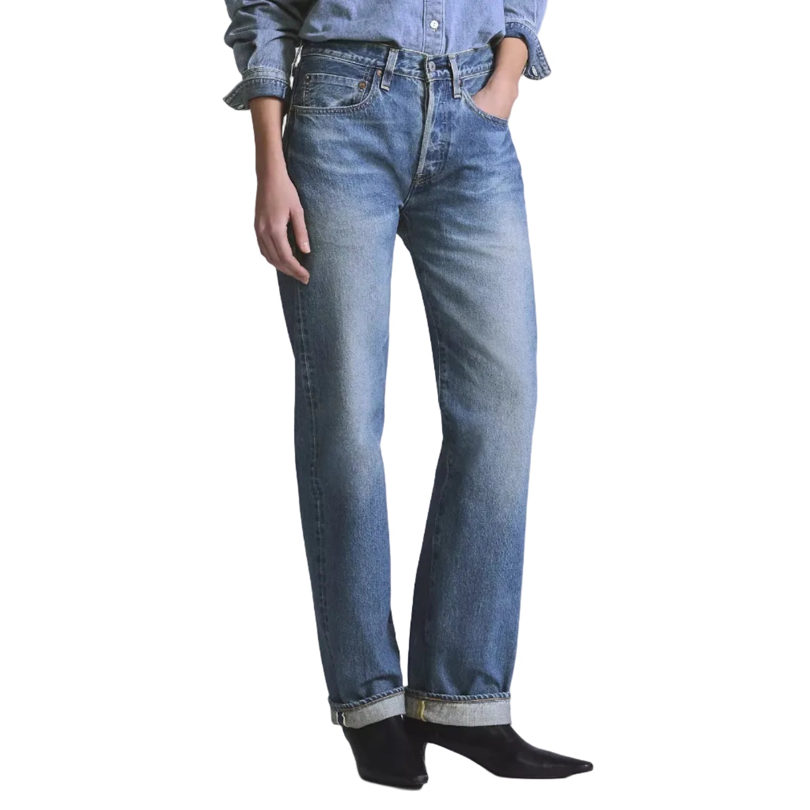 Person wearing a denim shirt and jeans on a light gray background