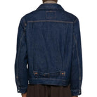 Blue denim jacket worn by a person on a white background