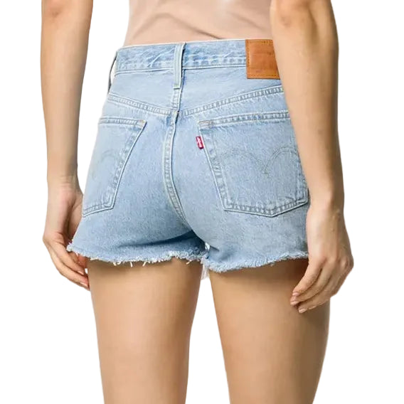 Person wearing light blue denim shorts on a white background