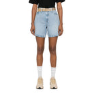Person wearing a black t-shirt, light blue denim shorts, and white socks with a white background
