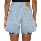 Person wearing light blue denim shorts on a white background