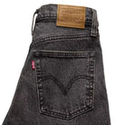Black Levi's jeans with a brand label on a white background