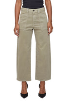 Person wearing beige wide-leg pants on a white background