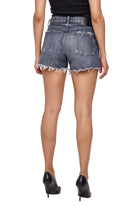 Rear view of a model wearing high-waisted, frayed-hem denim shorts in a washed black wash, paired with a black top and black high heels, against a white background.