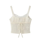 white camisole with delicate floral embroidery on a white background
