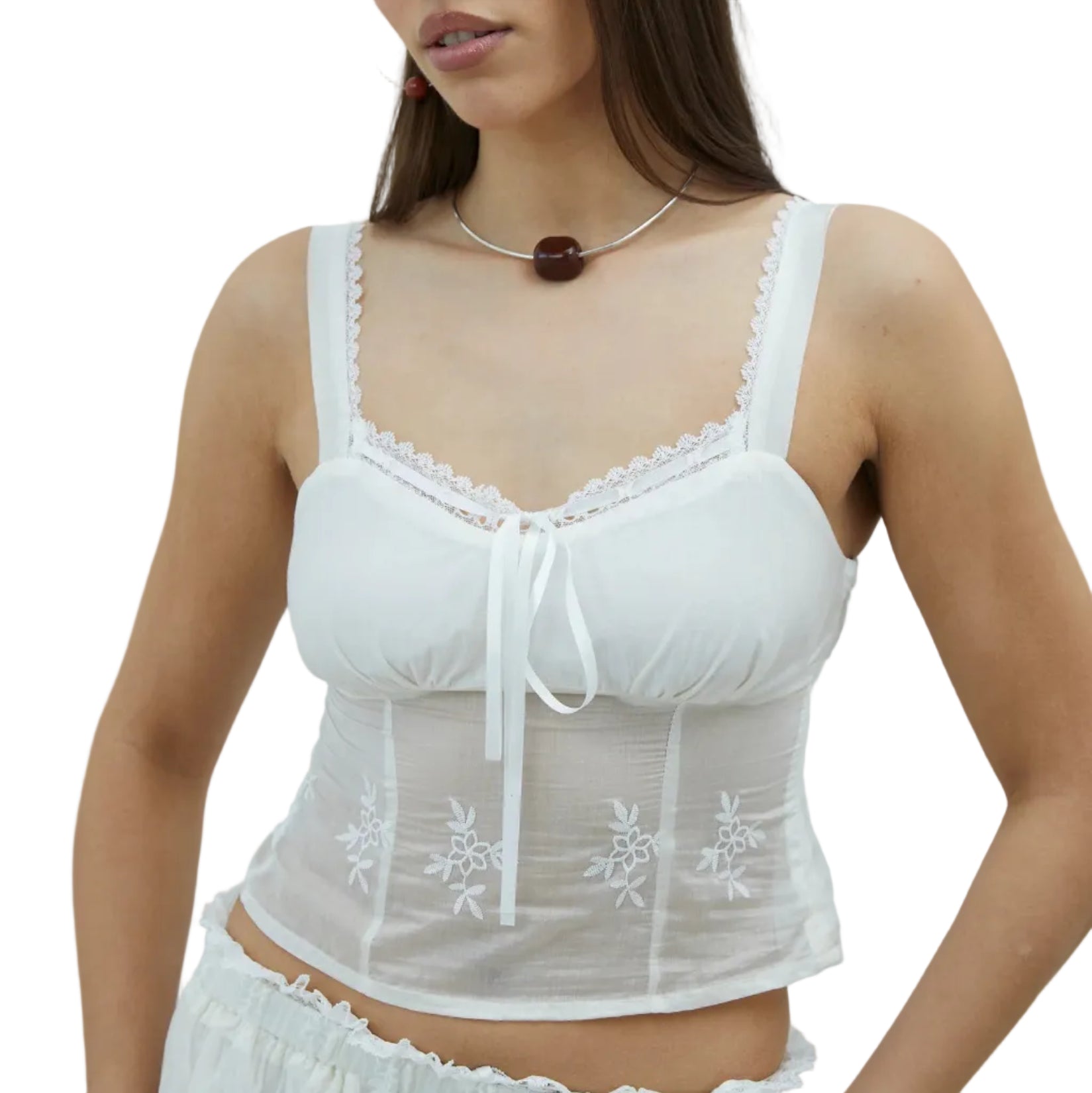 Model in a white camisole with delicate floral embroidery on a white background