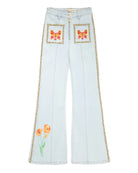 Light blue jeans with butterfly and flower embroidery on a white background