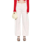 Woman wearing a red off-shoulder top and white pants on a white background